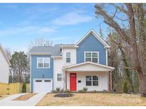 Two-story blue house with white accents, red door, and attached garage at 1000 Fairground St, Charlotte, NC 28208