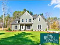 Charming two-story home featuring manicured lawn, complemented by verdant trees under clear blue skies at 1865 Rock Hill Church Rd # 3, Matthews, NC 28104