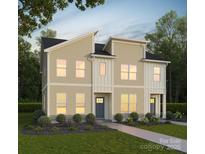 Tan three-unit townhome with gray doors, landscaping, and walkway at 815 Justice Ave, Charlotte, NC 28206