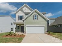 Charming two-story home with a two-car garage, green siding and landscaped yard at 1150 Red River Dr, Salisbury, NC 28144