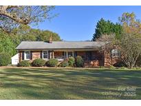 Charming single story brick home with manicured lawn, mature trees, and an inviting front porch at 115 Turner St, Lincolnton, NC 28092