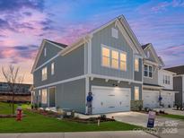 Charming two-story home featuring a two-car garage, craftsman details, and a beautifully landscaped front yard at 145 Halite Way, Waxhaw, NC 28173