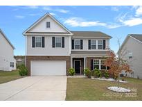 Charming two-story home with brick and siding, well-manicured lawn, and attached two-car garage at 7618 Fenn Way, Indian Land, SC 29707