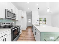 New kitchen with stainless steel appliances, a sleek backsplash, and a white countertop island with seating at 501 Ed Wilson Rd, Bessemer City, NC 28016