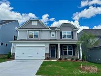 Charming two-story home featuring a two-car garage, stone accents, and a well-manicured lawn at 5115 Heathland Dr # 47, Charlotte, NC 28215