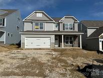 Charming two-story home with stone accents, gray siding, and a two-car garage on a sunny day at 5115 Heathland Dr # 47, Charlotte, NC 28215