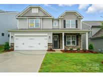 Charming two-story home featuring stone accents, a well-manicured lawn, and a two-car garage at 5115 Heathland Dr # 47, Charlotte, NC 28215