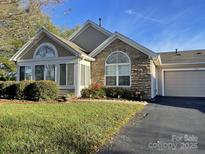 Charming ranch home with stone accents and landscaped lawn at 9013 Trellis Pointe Blvd, Charlotte, NC 28227