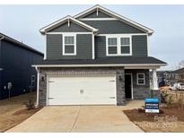 Two-story house with gray siding, stone accents, and a two-car garage at 102 Obadiah Ct, Troutman, NC 28115