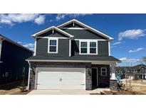 Two-story home with gray siding, stone accents, white trim, and a two-car garage at 102 Obadiah Ct, Troutman, NC 28115