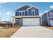 Lovely two-story home with a blue exterior, two-car garage, and a wide concrete driveway at 103 Obadiah Ct, Mooresville, NC 28115