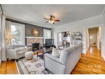 Inviting living room featuring a brick fireplace, ceiling fan, wood floors, and comfortable seating arrangement at 915 Finley Rd, Rock Hill, SC 29730
