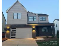 Beautiful two-story home with a modern garage door and complementary black brick and siding at 15008 Brownleigh Ln # 29, Huntersville, NC 28078