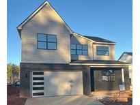 New two-story home featuring a modern garage door and black-framed windows at 15008 Brownleigh Ln # 29, Huntersville, NC 28078
