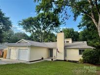 Charming one-story home with a well-manicured lawn, two-car garage, and inviting front entrance at 11800 Five Cedars Rd, Charlotte, NC 28226
