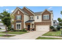 Charming two-story home with a two-car garage, stone accents, and a beautifully landscaped front yard at 13929 Tilesford Ln, Huntersville, NC 28078