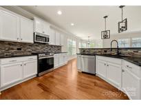 Spacious kitchen with white cabinets, stainless steel appliances, and hardwood floors at 13929 Tilesford Ln, Huntersville, NC 28078