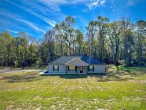 Charming single-story home with a well-manicured lawn and a backdrop of lush trees at 2215 Charlotte Hwy, York, SC 29745