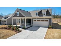 Beautiful two-story home featuring a front porch, two-car garage, and manicured landscaping at 2253 Millennium Dr # 009, Lancaster, SC 29720
