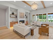 Bright living room features a fireplace, custom built-ins, a modern chandelier, and an abundance of natural light at 407 Crepe Myrtle Ln, Weddington, NC 28104