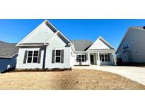 New home exterior boasts a charming light blue facade, gray shutters, and a welcoming front porch at 419 Lucky Nw Dr # 22, Concord, NC 28027