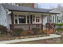 Charming single-story home featuring a covered front porch, gray siding, and well-maintained landscaping at 27 Sw Barbee Rd, Concord, NC 28027