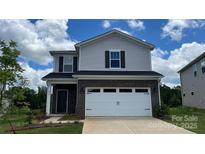 Charming two-story home with a brick and vinyl facade, complemented by a two-car garage and well-manicured lawn at 849 Blue Canyon Dr, York, SC 29745