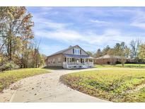 Charming home featuring a cozy front porch, surrounded by lush greenery and a winding driveway at 12300 Caldwell Rd, Charlotte, NC 28213