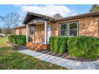 Brick ranch house with landscaped yard and a covered porch at 130 Island Park Ln, Statesville, NC 28625