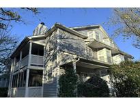 Two-story home featuring a front porch and upper balcony with white wooden railings and gray siding at 6017 Treetop Ct, Charlotte, NC 28212