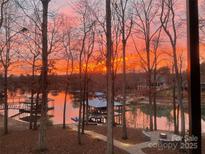 Lake view featuring colorful sunrise and boat dock at 3853 Gordon St, Terrell, NC 28682