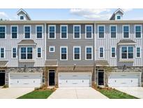 Three-unit townhome building with gray siding, brick accents, and two-car garages at 7112 Brookview Ln, Sherrills Ford, NC 28673