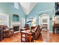 Living room with vaulted ceilings, hardwood floors, and fireplace at 20109 Norman Colony Rd, Cornelius, NC 28031