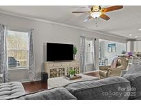 Open living room layout with hardwood floors, large TV, and seamless flow into the kitchen area at 7520 Berkeley W Rd, Denver, NC 28037