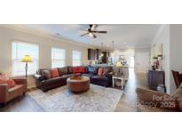 Bright living room featuring a ceiling fan, wood floors, and an open floor plan with a view to the kitchen at 280 Kerri Dawn Ln, Locust, NC 28097