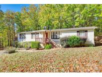Charming home with a yard covered in leaves and surrounded by lush green trees at 5320 Liberty Hill W Rd, York, SC 29745