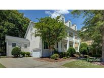Beautiful home with a two-story porch, well-maintained landscaping, and a driveway with a basketball hoop at 14027 Grand Traverse Dr, Charlotte, NC 28278