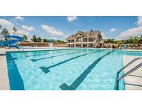 Large swimming pool with lap lanes, a slide, and community clubhouse in the background on a sunny day at 14027 Grand Traverse Dr, Charlotte, NC 28278