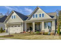 Two-story house with a front porch, landscaped yard, and attached two-car garage at 14535 Crosswater Ln, Charlotte, NC 28278