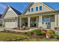 Two-story home with front porch, landscaping, and two-car garage at 14535 Crosswater Ln, Charlotte, NC 28278