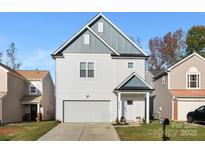 Two-story house with gray and white siding, a two-car garage, and a landscaped yard at 5723 Wallace Cabin Dr, Charlotte, NC 28212