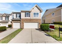 Inviting home featuring a stone facade, a two-car garage, and well-maintained landscaping at 14423 Glendon Hall Ln, Charlotte, NC 28262