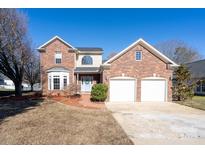 Brick two-story house with a two-car garage and landscaped lawn at 5580 Berry Ridge Dr, Harrisburg, NC 28075
