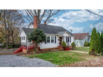 Charming white house with red steps, brick chimney, and landscaping at 1235 10Th Ne St, Hickory, NC 28601