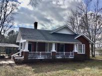 Charming single-story home featuring a brick facade and welcoming front porch at 8350 Nc Hwy 90 E Hwy, Stony Point, NC 28678