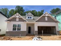 New home with brick accents, white siding, and attached two-car garage ready for your personal touch at 9130 Dulwich Dr # Ken0079, Charlotte, NC 28215