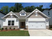 Charming home showcasing a manicured lawn, brick accents, and a well-lit two-car garage at 9130 Dulwich Dr # Ken0079, Charlotte, NC 28215