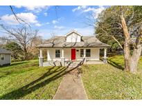 Charming home featuring a vibrant red front door and a welcoming covered porch at 612 E E St, Newton, NC 28658