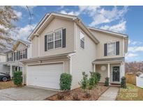 Tan two-story house with a white garage door and dark shutters at 7546 Lady Liberty Ln, Charlotte, NC 28217