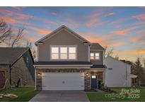 Two-story house with stone and shingle accents, two-car garage, and landscaping at 2033 White Cypress Ct # Kh06, Charlotte, NC 28216